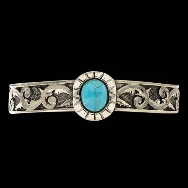 Every Cowgirl loves Turquoise! This cuff bracelet is crafted on a German Silver base with a matted base and antique finish. Detailed with a Beautiful Turquoise Stone in the center. 6" x .5"

Pair with a Cow Tag Necklace or a Custom Belt Buckle